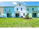 Townhome backyards with colorful exteriors offer sliding glass doors and Adirondack chairs on the manicured lawns at 3192 Caribbean Soul Dr, Kissimmee, FL 34747