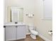 Charming bathroom with grey vanity, decorative mirror, sink, toilet, white walls, and decorative flooring at 3192 Caribbean Soul Dr, Kissimmee, FL 34747