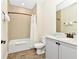 Modern bathroom featuring a shower-tub combo, a neutral tile backsplash, and a grey vanity at 3192 Caribbean Soul Dr, Kissimmee, FL 34747