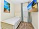 Single bedroom with tile floor, television, beach themed artwork and blue curtains at 3192 Caribbean Soul Dr, Kissimmee, FL 34747