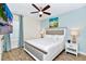 Inviting bedroom featuring a king bed, wood-look tile flooring, a TV, fan, and beach-themed wall art at 3192 Caribbean Soul Dr, Kissimmee, FL 34747