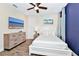 Cozy bedroom with wood-look tile flooring, white furniture, and a ceiling fan at 3192 Caribbean Soul Dr, Kissimmee, FL 34747