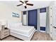 Stylish bedroom featuring a white bed, luxury linens, light gray walls, and wood-look tile flooring at 3192 Caribbean Soul Dr, Kissimmee, FL 34747