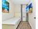 Single bedroom with tile floor, television, beach themed artwork and blue curtains at 3192 Caribbean Soul Dr, Kissimmee, FL 34747