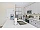 Bright kitchen with stainless steel appliances, quartz countertops, white cabinets, and wood tile flooring at 3192 Caribbean Soul Dr, Kissimmee, FL 34747