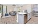 Bright kitchen with an eat-in bar and open concept view of the dining room with a wooden table at 3192 Caribbean Soul Dr, Kissimmee, FL 34747