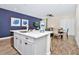 Bright kitchen with an eat-in bar and open concept view of the dining room with a wooden table at 3192 Caribbean Soul Dr, Kissimmee, FL 34747