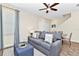 Inviting living room featuring a comfortable gray sofa, ceiling fan, and seamless flow to the dining area at 3192 Caribbean Soul Dr, Kissimmee, FL 34747