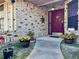 Inviting front porch with brick facade and a red front door with decorative potted plants at 324 Bonita Rd, Debary, FL 32713