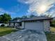 Close up view of a single story home's two-car garage and driveway on a sunny day at 324 Bonita Rd, Debary, FL 32713
