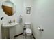 Clean half bathroom with pedestal sink, toilet, decorative mirror, and light fixtures at 324 Bonita Rd, Debary, FL 32713