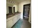 Bathroom with a double-sink vanity featuring granite countertops and a tiled walk-in shower at 3990 Lana Ave, Davenport, FL 33897