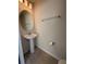 Practical powder room featuring a pedestal sink, round mirror, and tile flooring at 3990 Lana Ave, Davenport, FL 33897