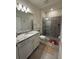 Modern bathroom featuring a granite vanity, glass-enclosed shower, and stylish tile flooring at 3990 Lana Ave, Davenport, FL 33897