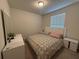 Cozy bedroom with a comfortable bed, white furniture, and natural light from the window at 3990 Lana Ave, Davenport, FL 33897
