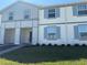 Charming two-story townhome featuring light blue shutters and a well-manicured lawn on a sunny day at 3990 Lana Ave, Davenport, FL 33897