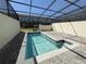 Relax in this screened in pool with a water view and patio area at 3990 Lana Ave, Davenport, FL 33897
