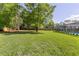 Expansive backyard with lush green lawn, mature trees, and enclosed pool area, perfect for outdoor living at 400 Royal Palm Ct, Longwood, FL 32779