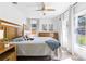Comfortable bedroom with a wood-framed bed, soft linens, and natural light from the windows at 400 Royal Palm Ct, Longwood, FL 32779