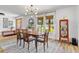 Formal dining room with modern chandelier, light gray rug, and view of the landscaped front yard at 400 Royal Palm Ct, Longwood, FL 32779