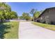Spacious driveway leading to the home with a well-manicured lawn and a hint of the home's exterior at 400 Royal Palm Ct, Longwood, FL 32779