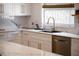 Modern kitchen sink with a view to the backyard, bright white cabinets, and marble countertops at 400 Royal Palm Ct, Longwood, FL 32779