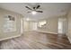 Open living room with wood-look floors, natural light, and seamless flow to the kitchen at 404 Summit Ridge Pl # 110, Longwood, FL 32779