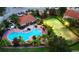Aerial view of the community pool, tennis court, and clubhouse nestled among palm trees at 4720 Hemingway House St, Kissimmee, FL 34746