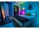 Neon-lit bedroom with unique modern bed, entertainment center, arcade game, and Star Wars wall decor at 4720 Hemingway House St, Kissimmee, FL 34746
