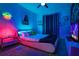Modern bedroom with neon accents, unique bed frame, TV, and Star Wars themed decor at 4720 Hemingway House St, Kissimmee, FL 34746