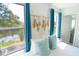 Cozy bedroom featuring a macrame wall decoration, natural light from the window, and blue accent curtains at 4720 Hemingway House St, Kissimmee, FL 34746