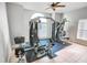 Spacious home gym equipped with a multi-station weight machine and an arched window for natural light at 4720 Hemingway House St, Kissimmee, FL 34746