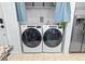 Convenient laundry closet featuring a modern washer and dryer set, with storage shelves above and a fridge next to it at 4720 Hemingway House St, Kissimmee, FL 34746