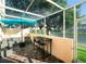 Relaxing screened-in patio with comfortable seating and a dining area, overlooking a serene pond view at 4720 Hemingway House St, Kissimmee, FL 34746