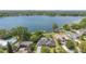 Beautiful aerial shot of a lakeside property featuring a private pool, dock, and lush greenery with the city visible at 673 Balmoral Rd, Winter Park, FL 32789