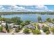 Stunning aerial view of a lakeside home with a private dock, lush landscaping, and a glimpse of the city skyline at 673 Balmoral Rd, Winter Park, FL 32789