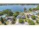 Aerial view of a lakeside home featuring lush landscaping, a private dock, and serene water views at 673 Balmoral Rd, Winter Park, FL 32789