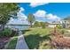 Lush backyard with a pathway leading to waterfront, complete with mature trees and verdant lawn at 673 Balmoral Rd, Winter Park, FL 32789