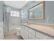 A bathroom with white cabinets, a large mirror, and a shower/tub combo at 673 Balmoral Rd, Winter Park, FL 32789