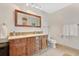Rustic bathroom features a wood vanity with double sinks, a large mirror, and neutral tiling at 673 Balmoral Rd, Winter Park, FL 32789