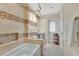 An updated bathroom with a soaking tub and mosaic tiled accents at 673 Balmoral Rd, Winter Park, FL 32789