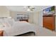 Cozy bedroom with white bedding, wood furniture, ceiling fan and a view of the waterway at 673 Balmoral Rd, Winter Park, FL 32789