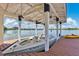 Boat dock featuring a covered boat lift with a sleek powerboat and kayaks for water activities at 673 Balmoral Rd, Winter Park, FL 32789