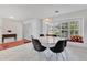 Open-concept dining area with a round table, modern lighting and a window seat overlooking the backyard at 673 Balmoral Rd, Winter Park, FL 32789