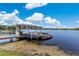Picturesque dock on a calm lake, featuring a covered structure and colorful kayaks ready for adventure at 673 Balmoral Rd, Winter Park, FL 32789