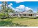 Charming single-story home featuring a well-manicured lawn, mature landscaping and a covered front porch at 673 Balmoral Rd, Winter Park, FL 32789