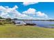 Expansive lake view featuring a dock with a covered sitting area and lush green landscaping at 673 Balmoral Rd, Winter Park, FL 32789