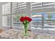Sunlit window with shutters offers scenic water views, complemented by a floral arrangement at 673 Balmoral Rd, Winter Park, FL 32789