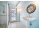 Bright bathroom features a walk-in shower, pedestal sink, and a door to the pool area at 690 S Lakemont Ave, Winter Park, FL 32792