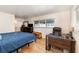 Cozy bedroom features a wooden desk, dresser, and a bright window for a comfortable and functional space at 690 S Lakemont Ave, Winter Park, FL 32792